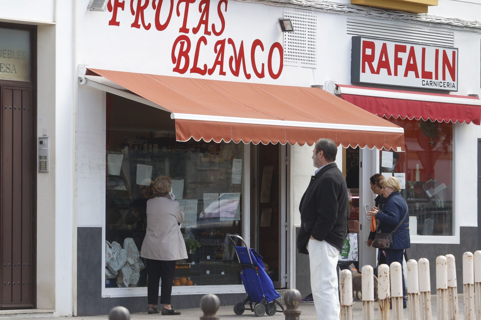 Varias personas esperan a la entrada de dos comercios de cercanía de Córdoba capital.