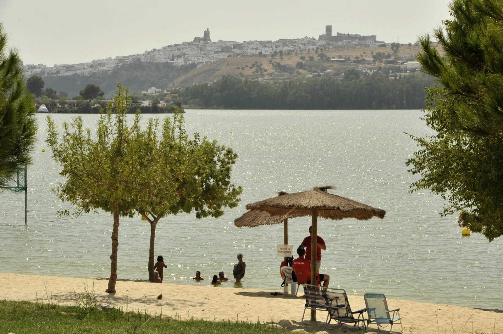 La playa del lago de Arcos, con el pueblo al fondo.
