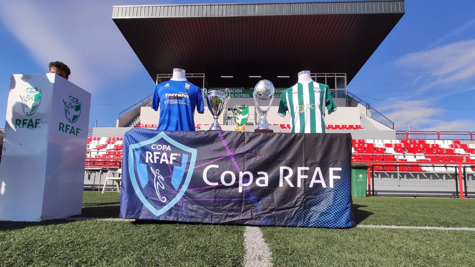 Las copas de campeón y subcampeón y las indumentarias de ambos equipos.