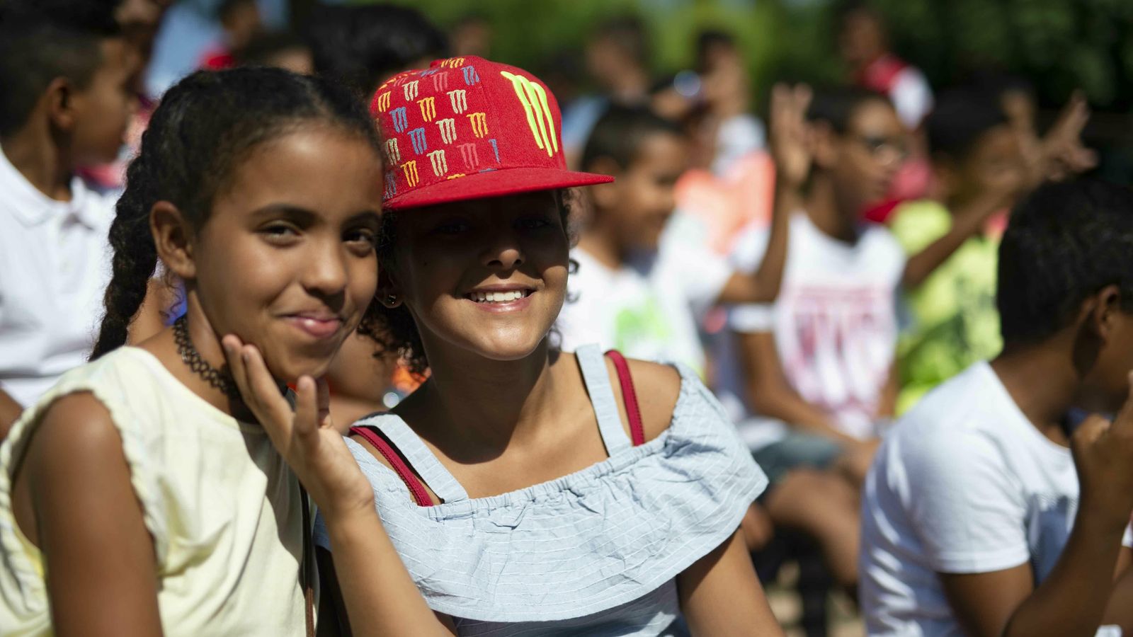 Dos niñas sonríen a cámara.