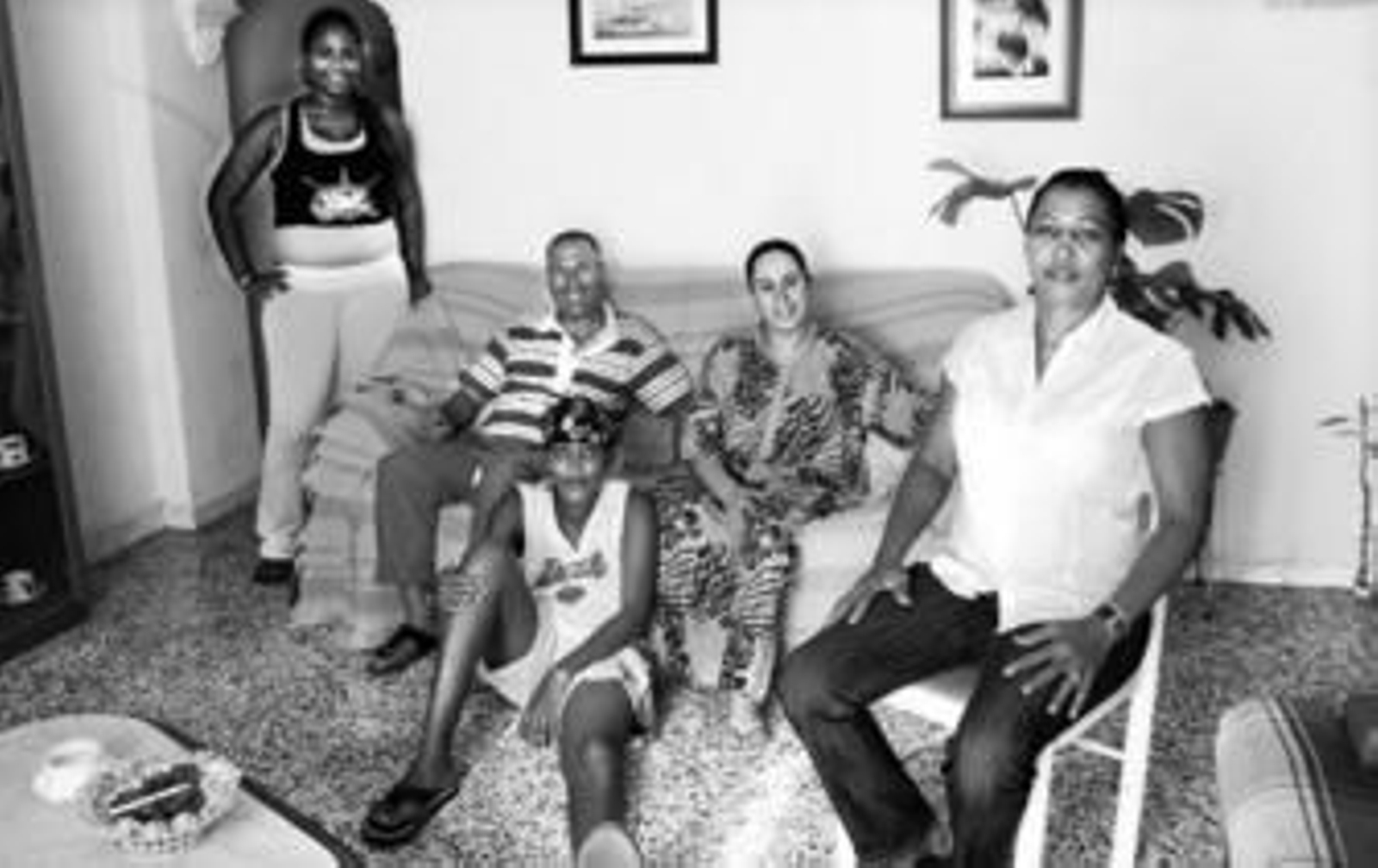 Los marroquíes Adud y Asma (sentados en el sofá) junto a la dominicana Lucida y sus hijos, dos familias que comparten piso en Su Eminencia.