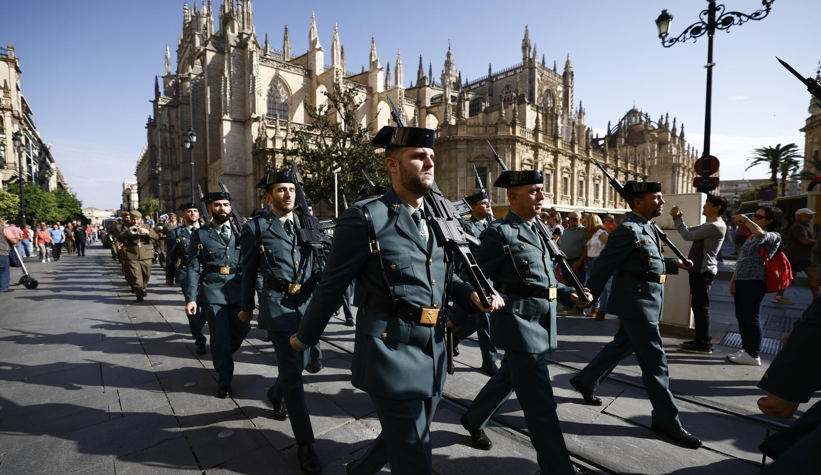 El izado de bandera y desfile militar por el centro de Sevilla, en imágenes