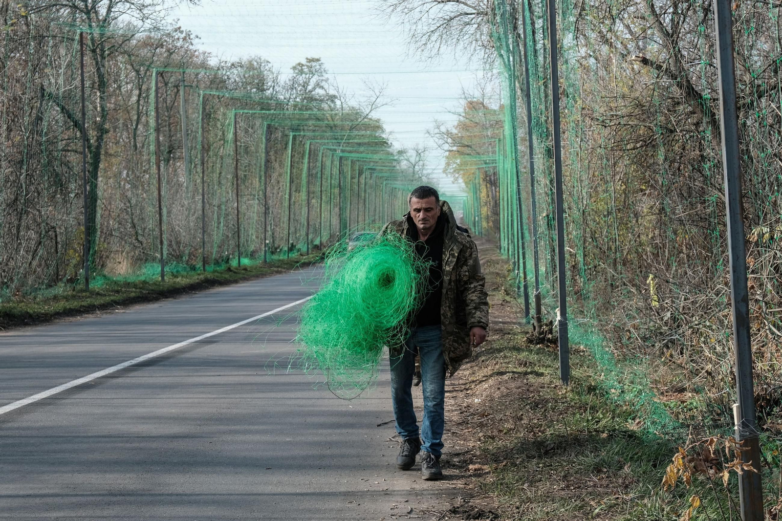 Un soldado ucraniano instala redes antidrones en las carreteras cercanas al frente en Donetsk.