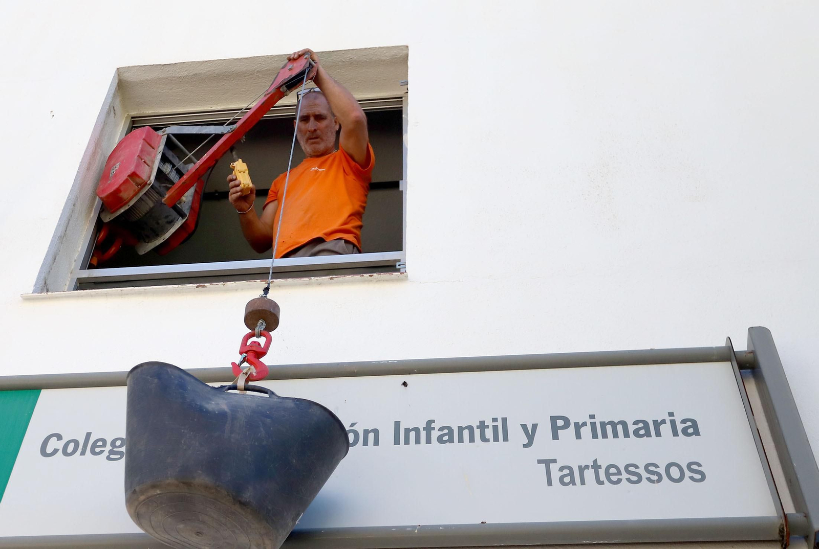 Un operario en la fachada del CEIP Tartessos, en la capital onubense. Un operario en la fachada del CEIP Tartessos, en la capital onubense.