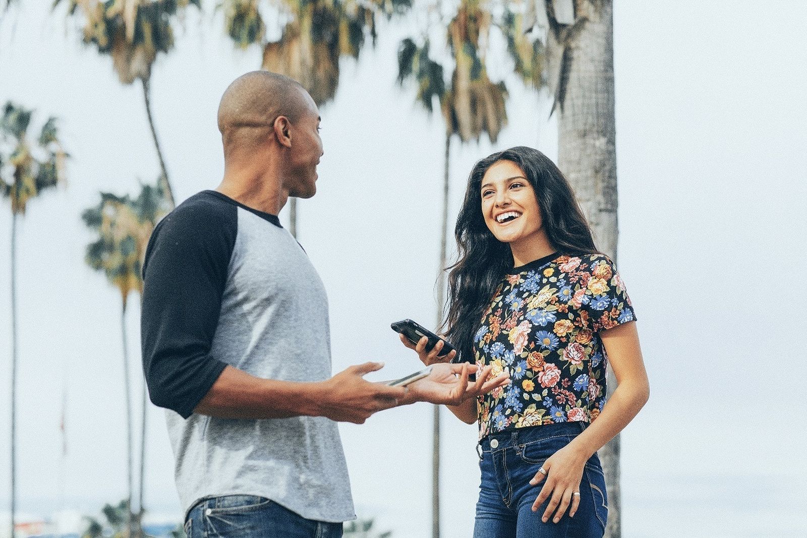 Dos jóvenes usan sus teléfonos móviles para ligar.