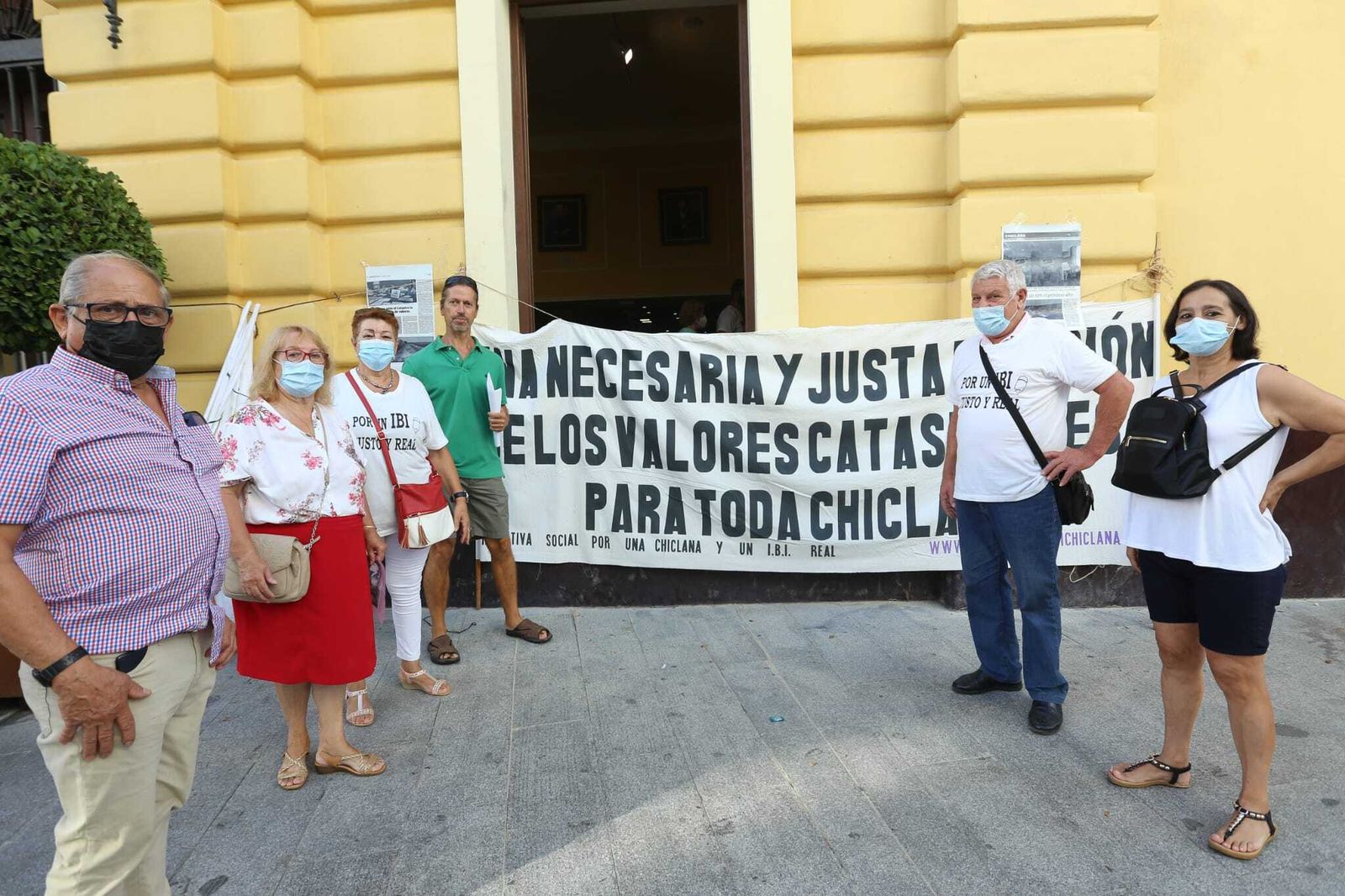 Miembros de la asociación y de otros colectivos junto a una de las pancartas durante el acto de protesta