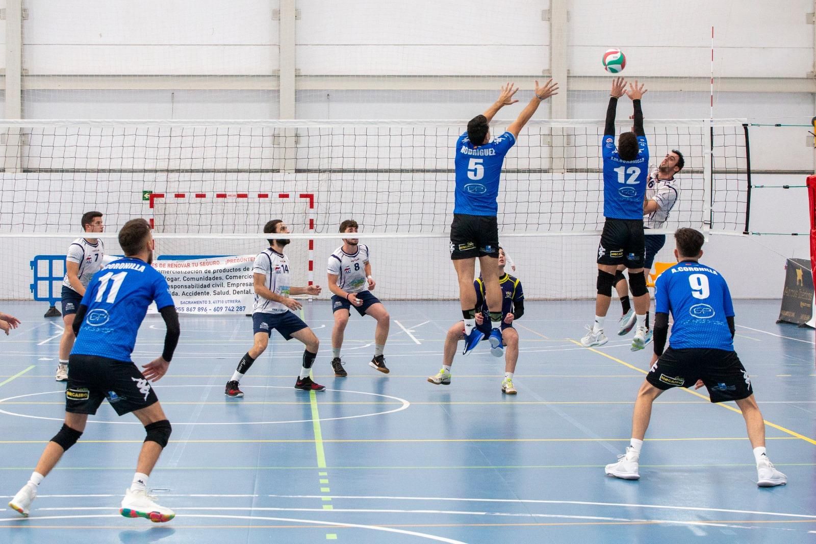 El doble bloqueo utrerano trata de frenar un remate rival.