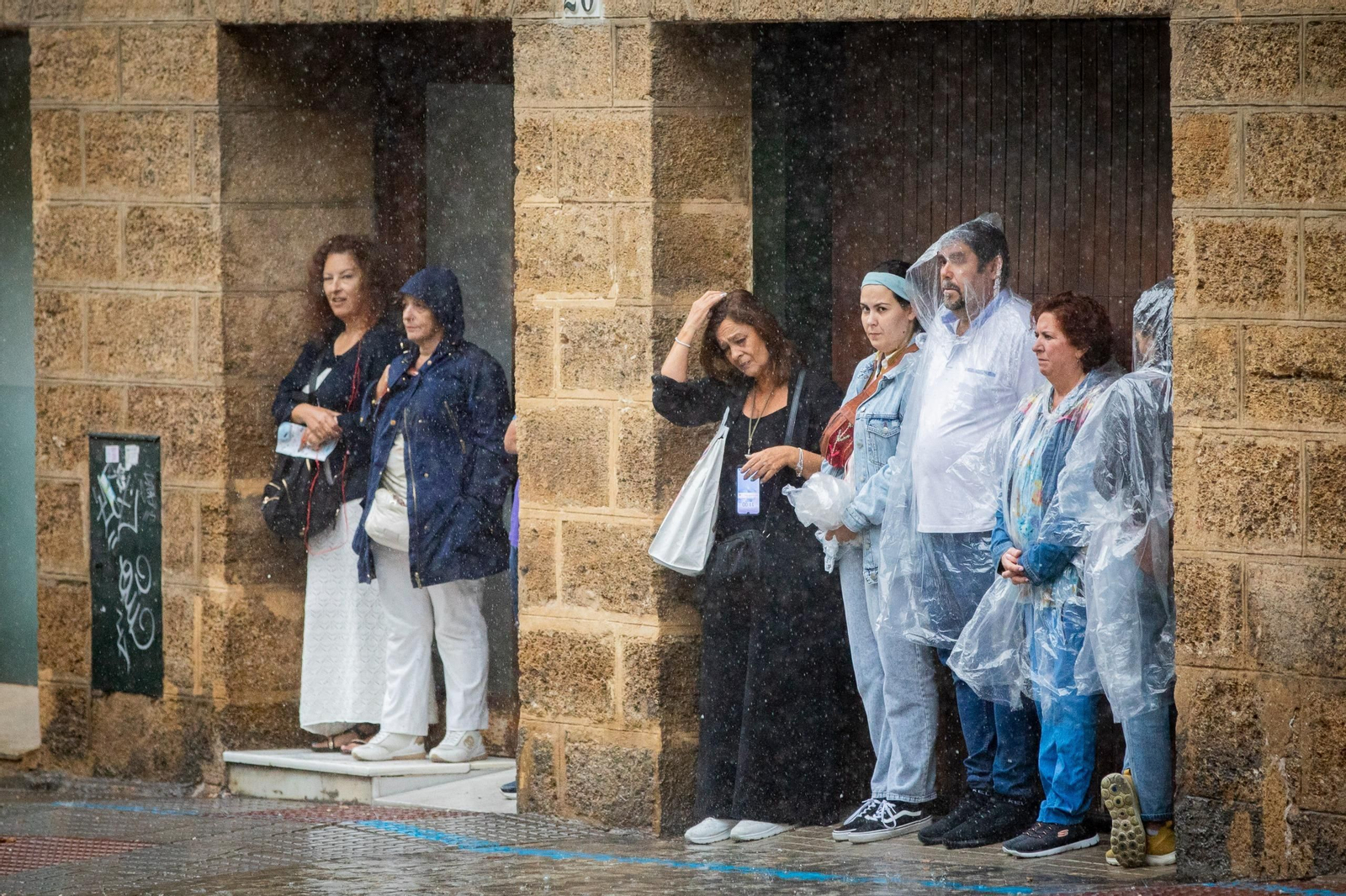 Personas protegiéndose de la lluvia en la jornada del domingo en Cádiz.