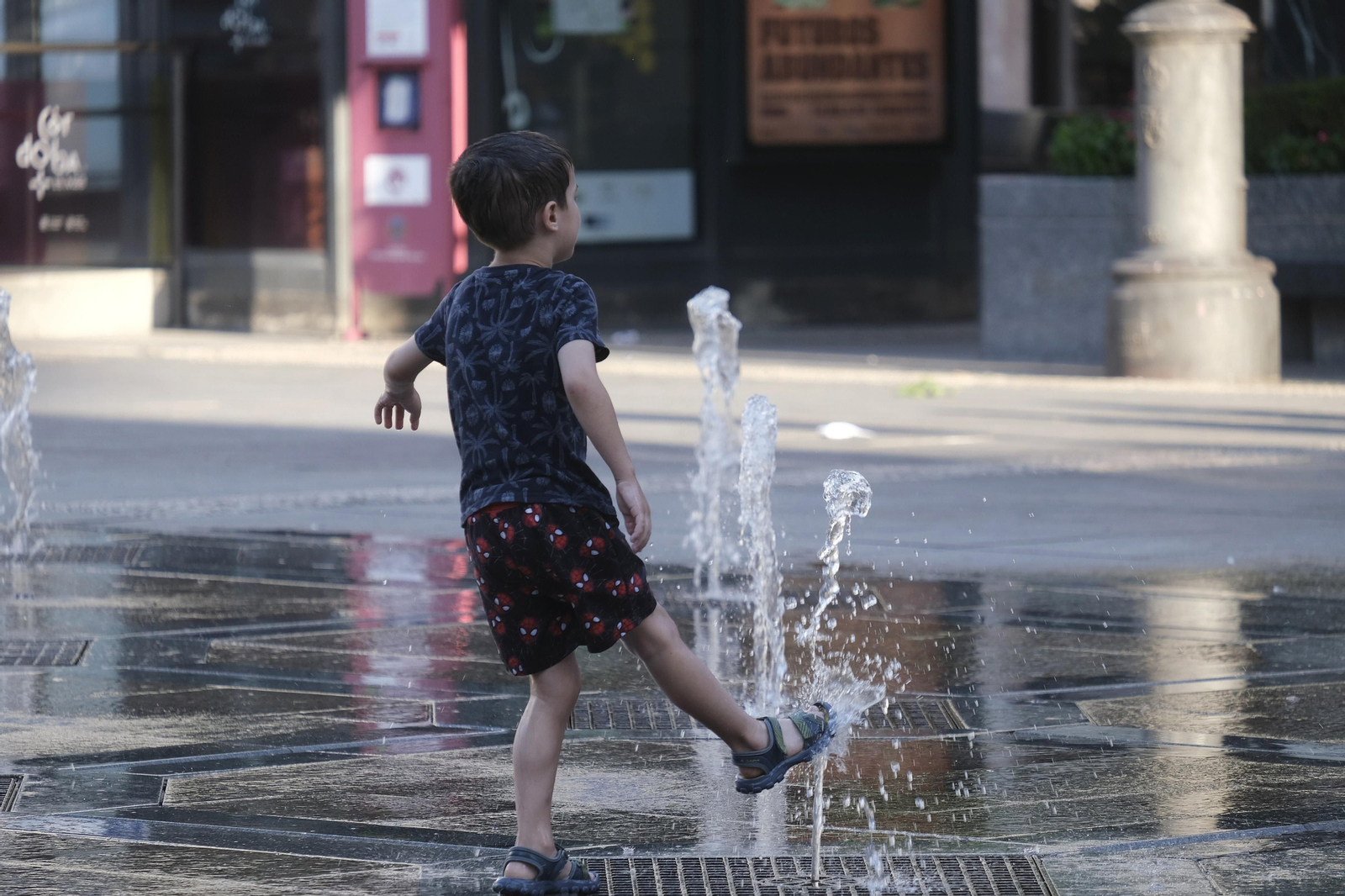 Un niño se refresca en una fuente de Córdoba este sábado.
