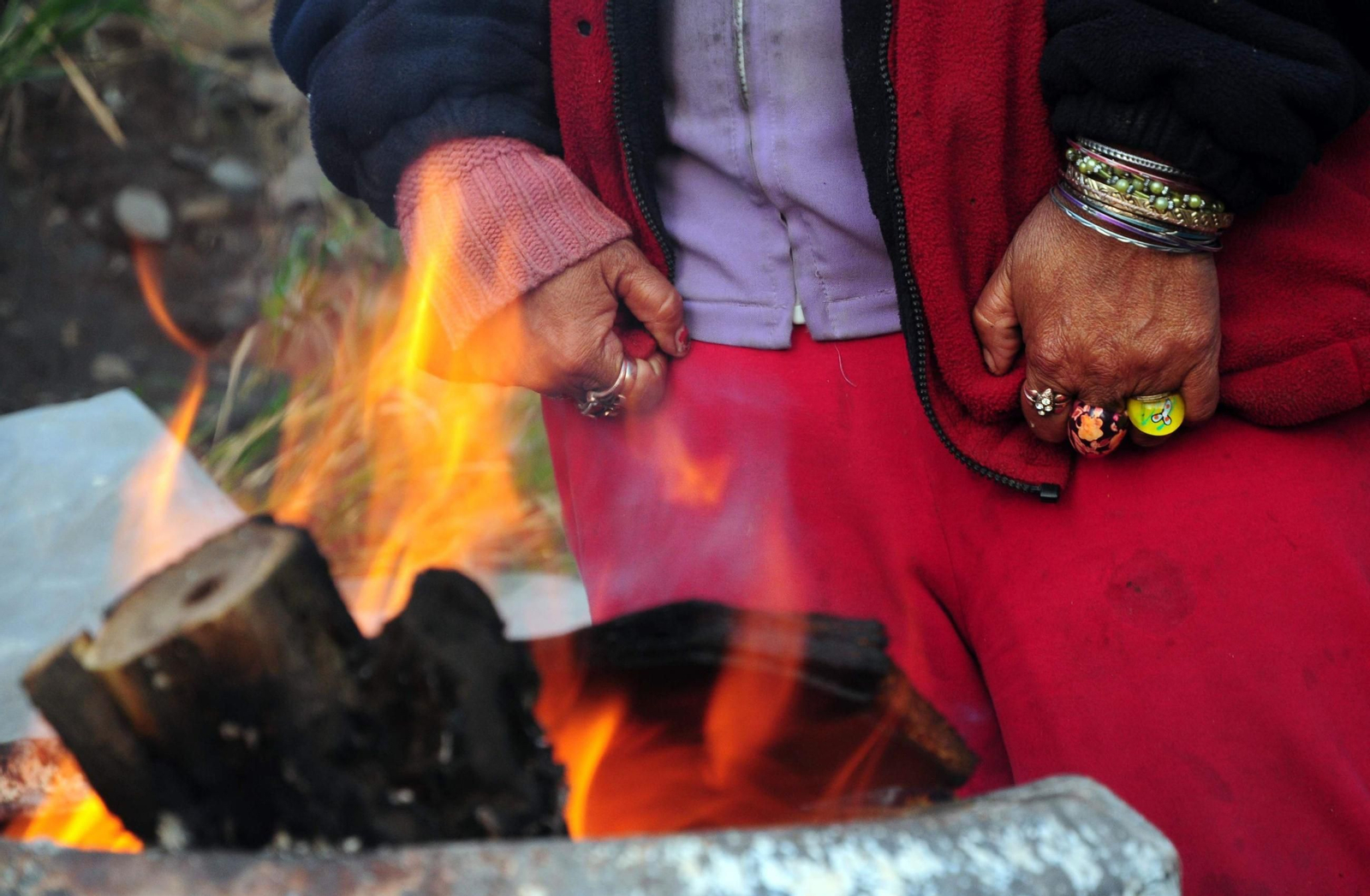 Una persona se calienta en la calle en un día de frío.
