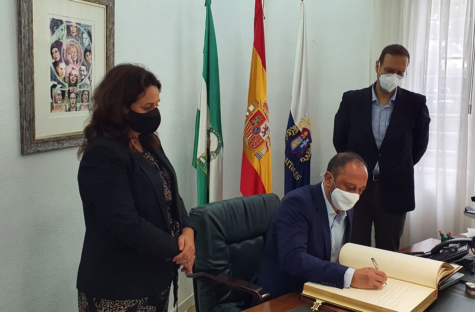 Alfonso Rodríguez Gómez de Celis, firmando en el Libro de Honor del Ayuntamiento de Espartinas, junto a la alcaldesa y el secretario.
