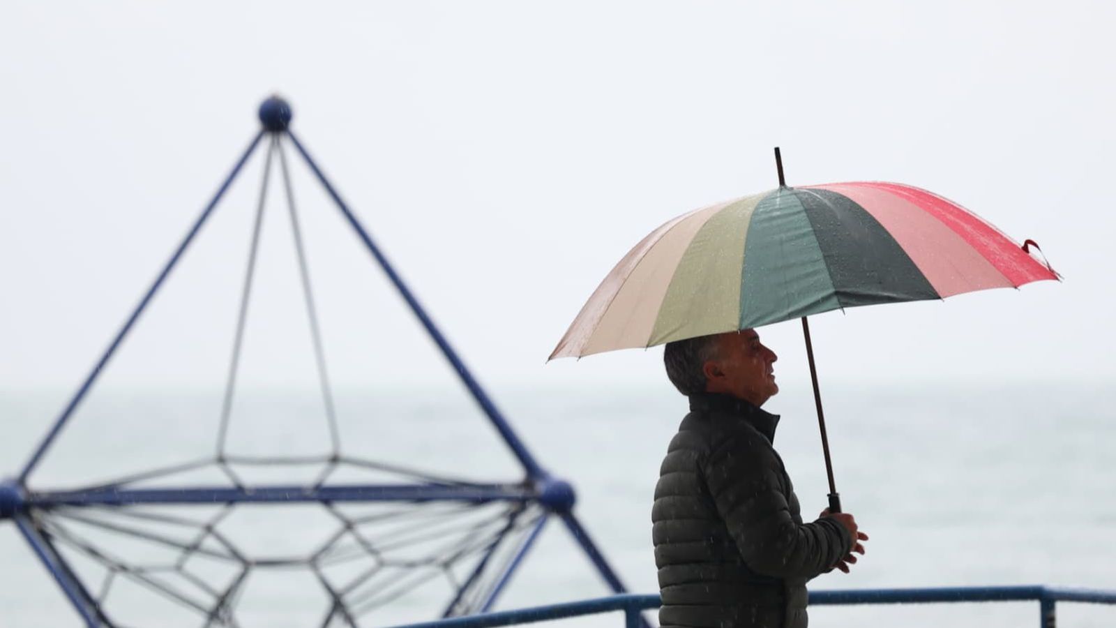 Hombre paseando bajo la lluvia en Málaga