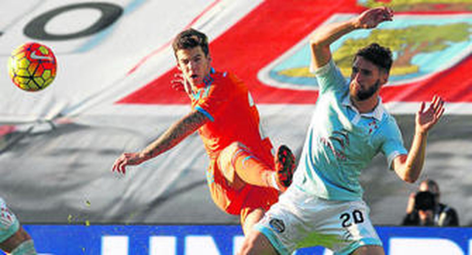 El valencianista Santi Mina dispara ante la oposición del defensa Sergi Gómez.