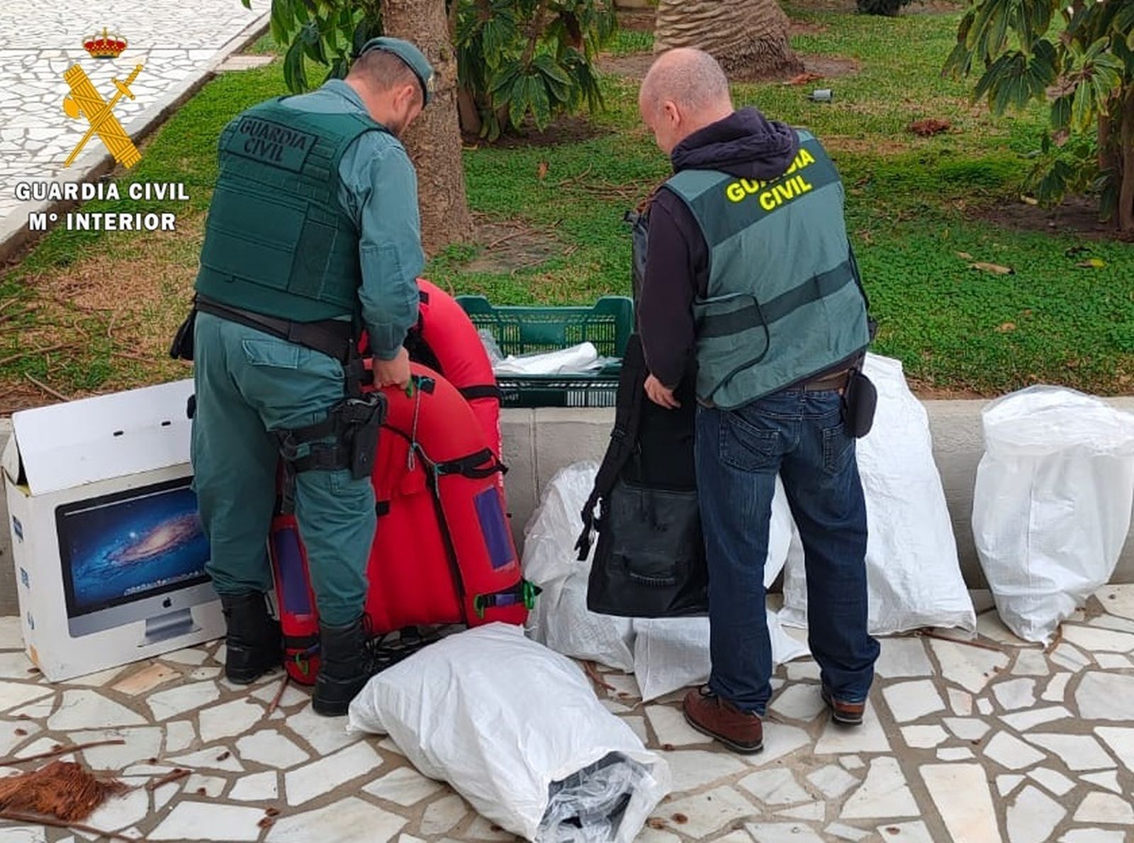 Dos agentes de la Guardia Civil con parte de los materiales intervenidos.