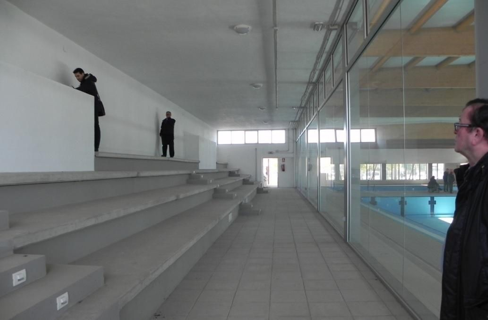 Operarios en la zona de grada de la piscina.
