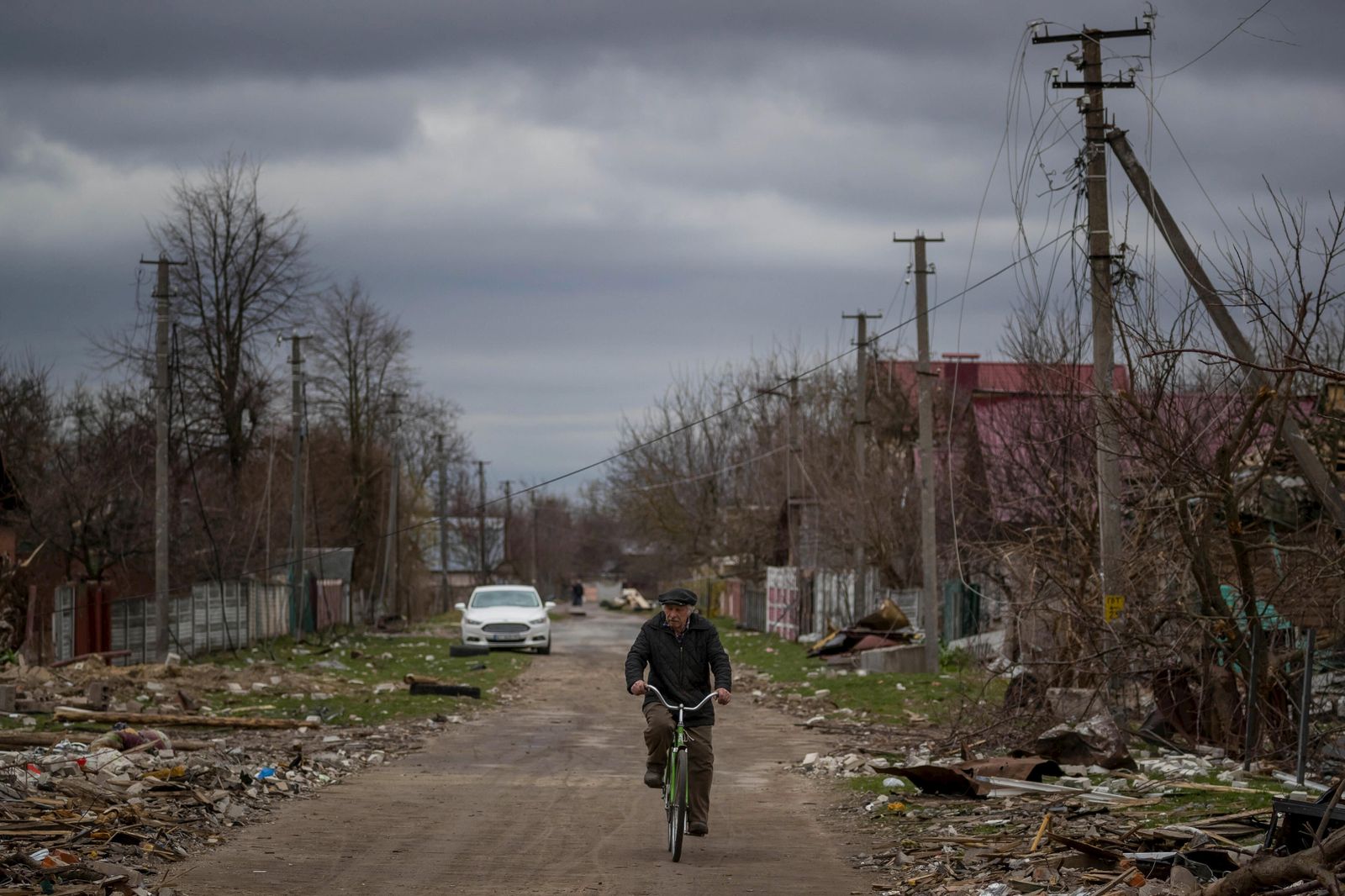 Un hombre maneja bicicleta por una calle afectada por proyectiles de alto calibre hoy