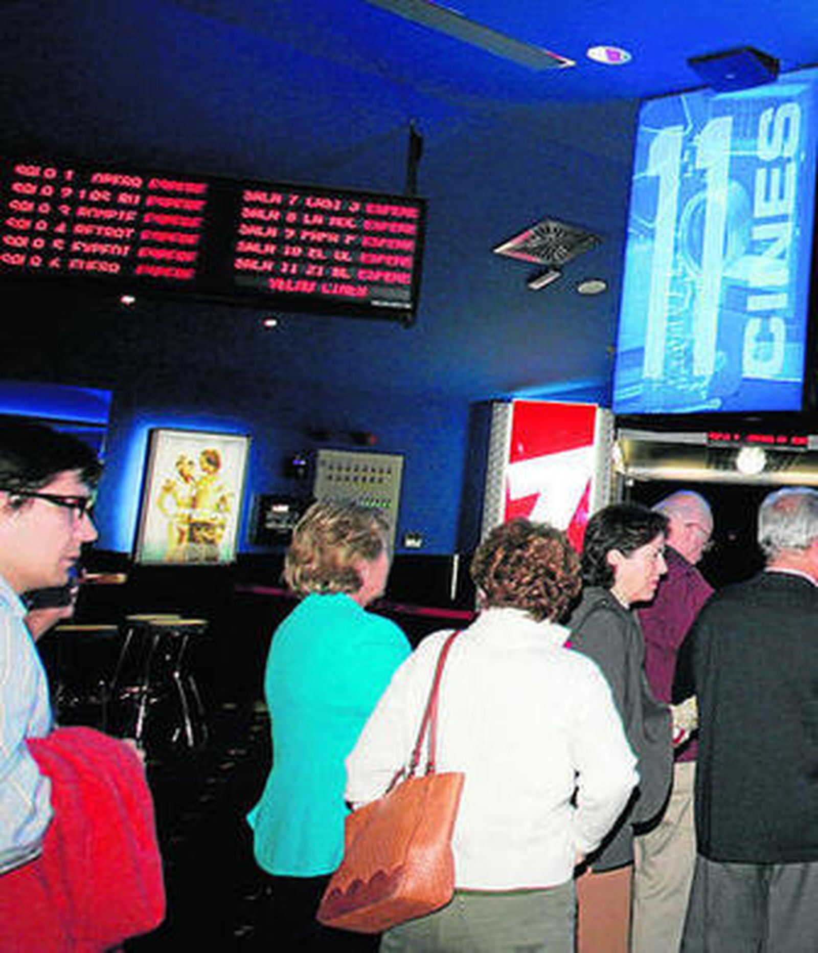 Un grupo de personas guarda cola ante la taquilla de un cine.