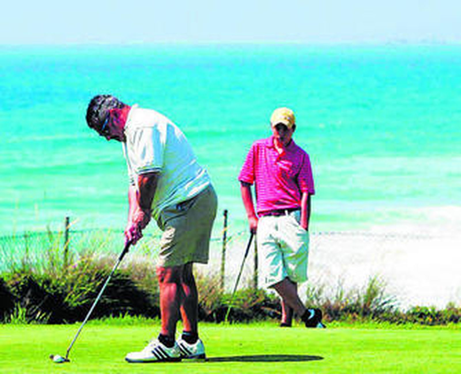 Unos turistas juegan al golf.