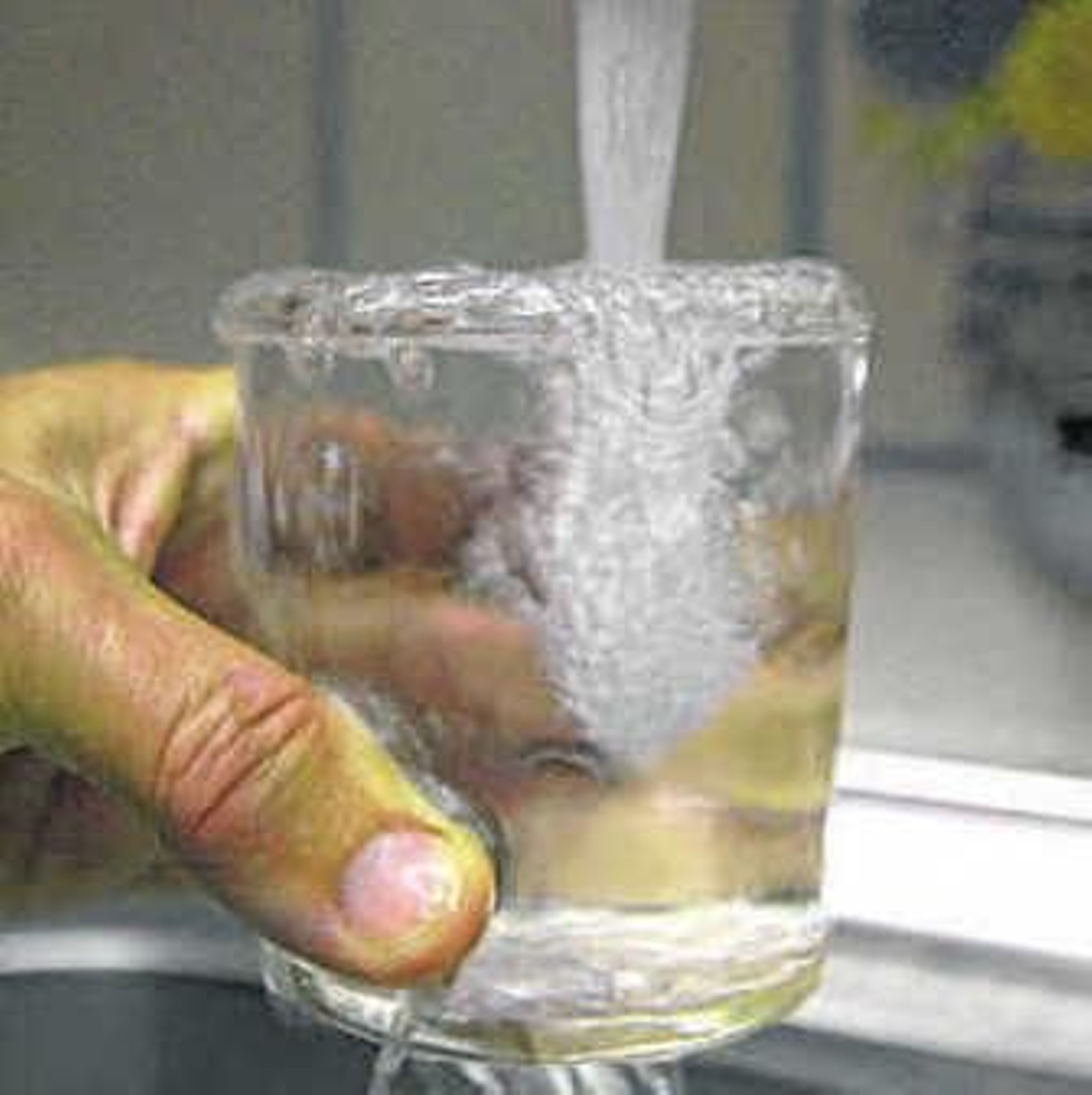 Un abonado llena un vaso de agua. Un abonado llena un vaso de agua.