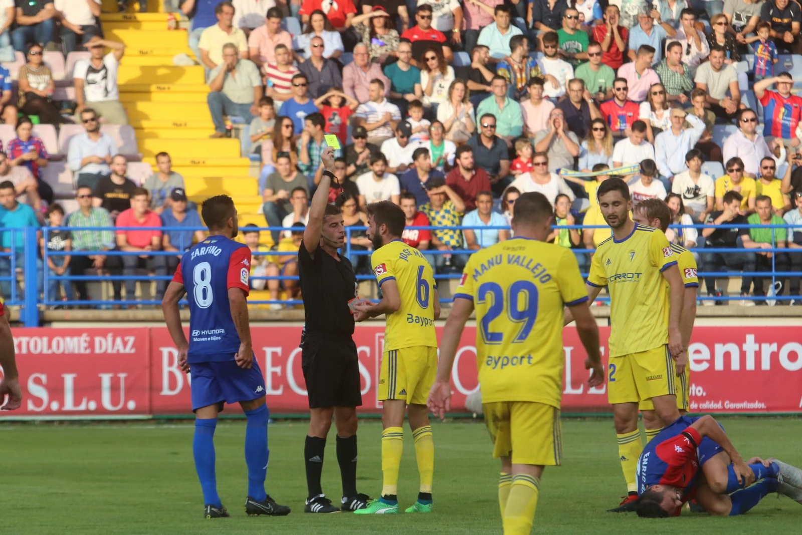 El colegiado amonesta a José Mari tras una entrada sobre Enric Gallego.