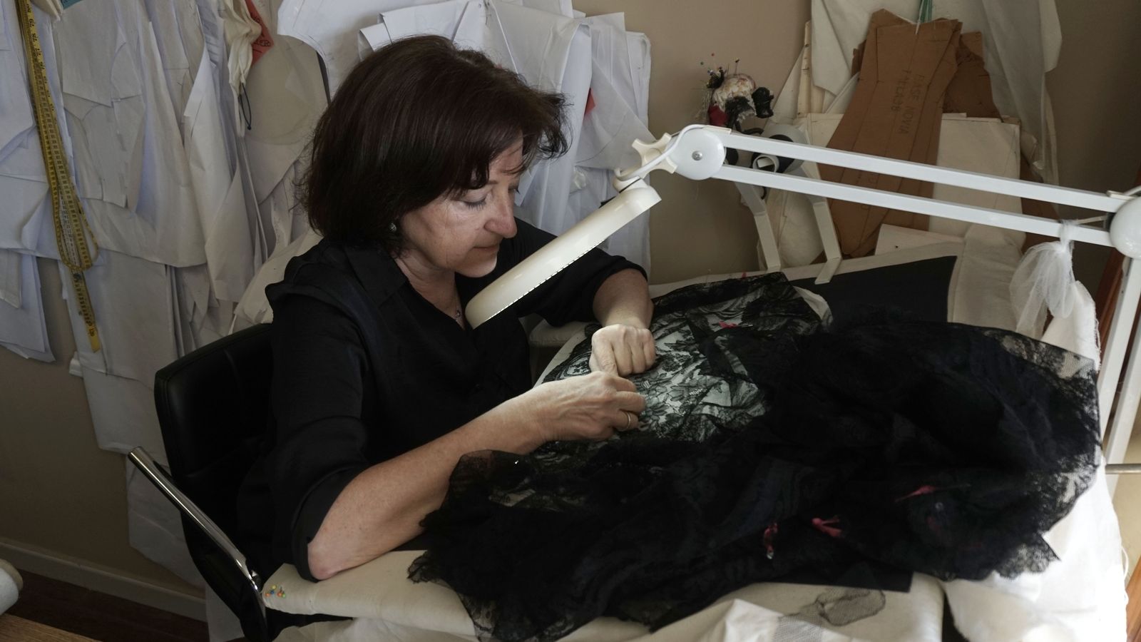 María Ramos usa una gran lupa para recomponer los hilos rotos de la mantilla.