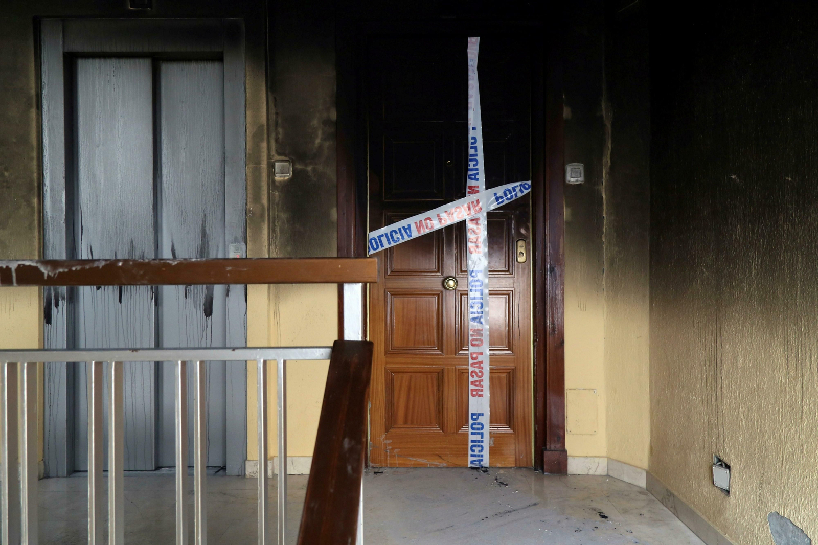 Estado en el que quedó el rellano de la planta del piso incendiado en Granada.