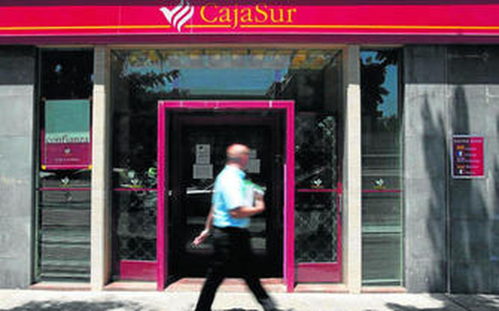 Un hombre pasa por delante de una oficina de Cajasur.
