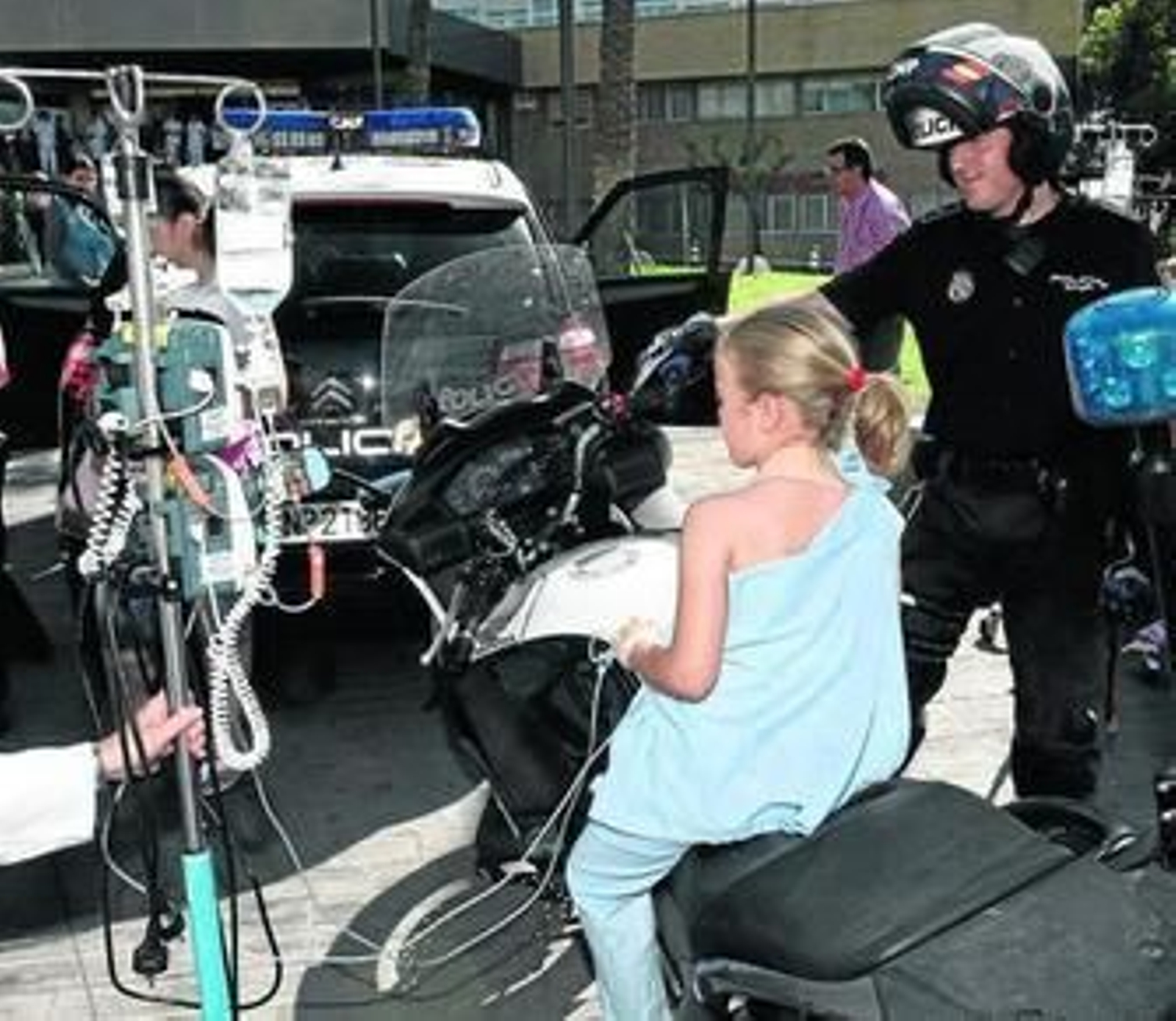 Una niña, en una moto de la Policía Nacional, en una visita de la misma a un hospital.
