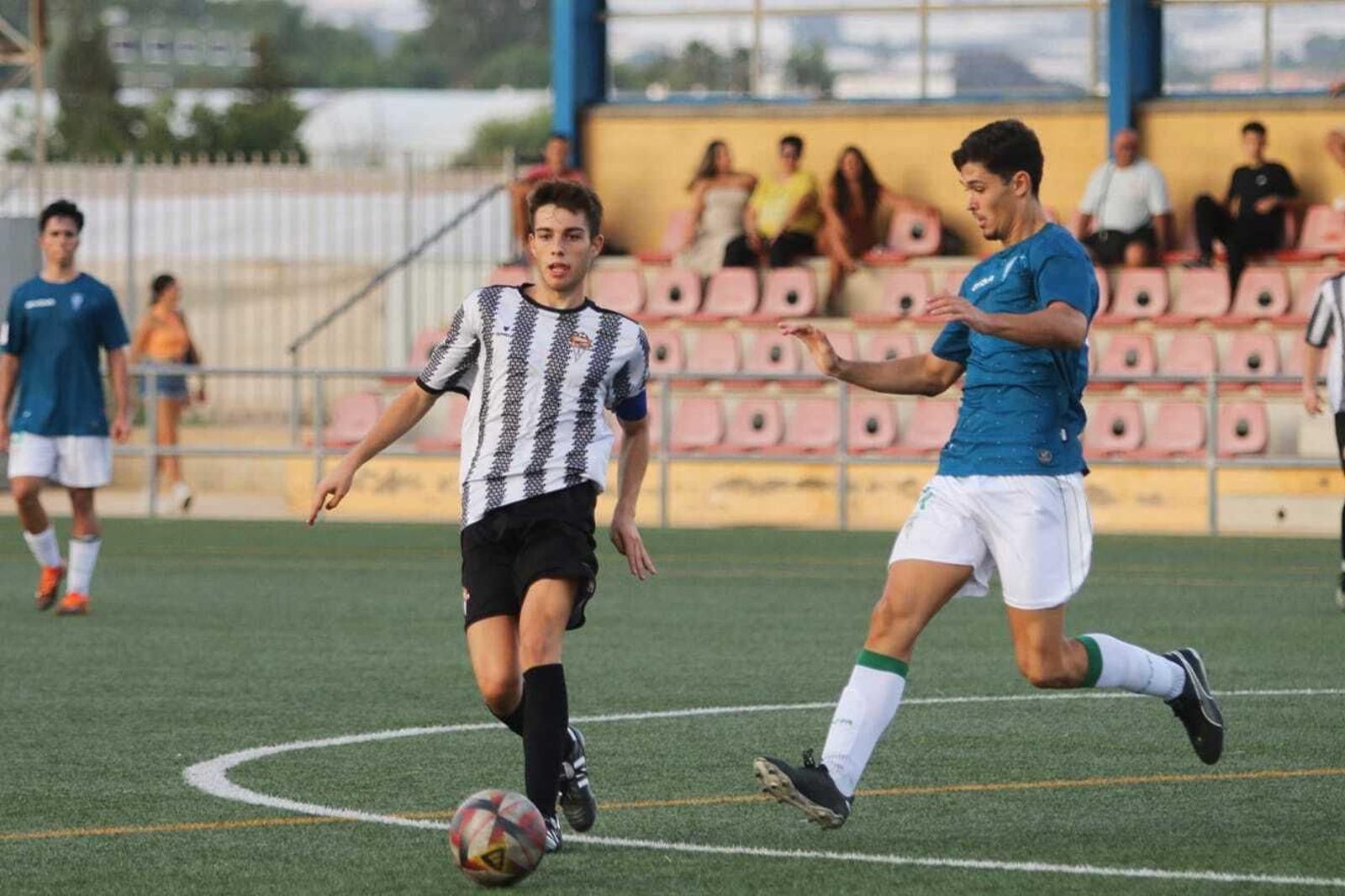 Un jugador de La Cañada da un pase ante la oposición de un rival en un partido en casa.