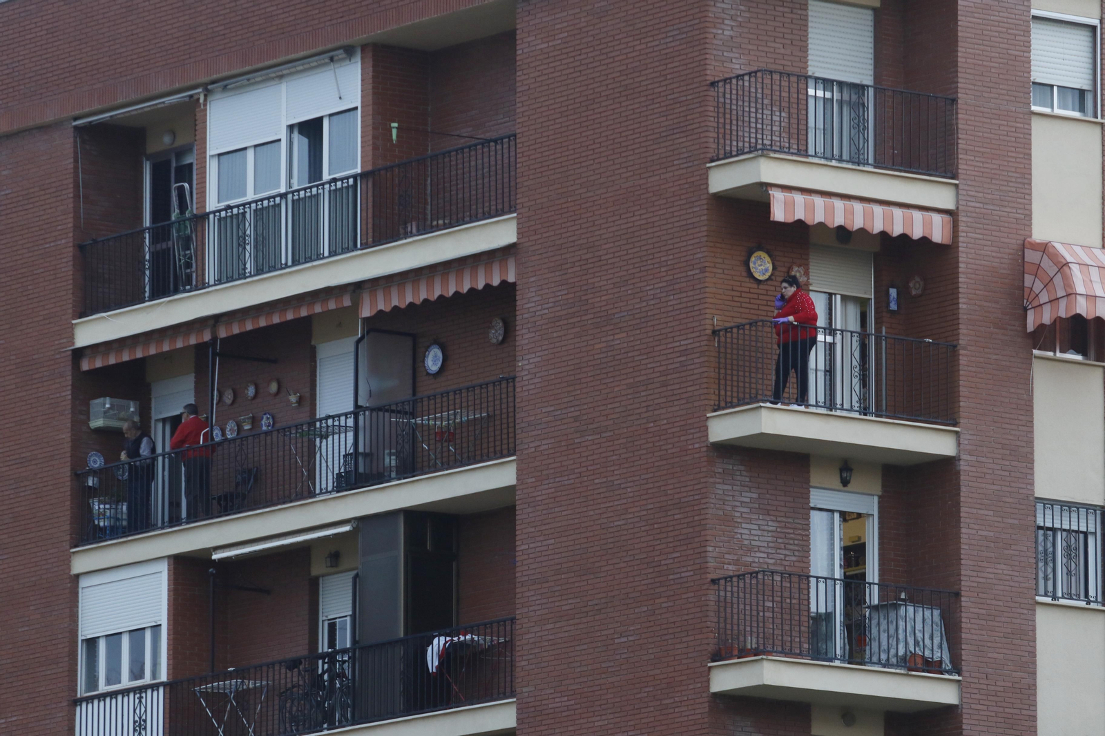 Varias personas toman el aire en sus balcones durante el estado de alarma.