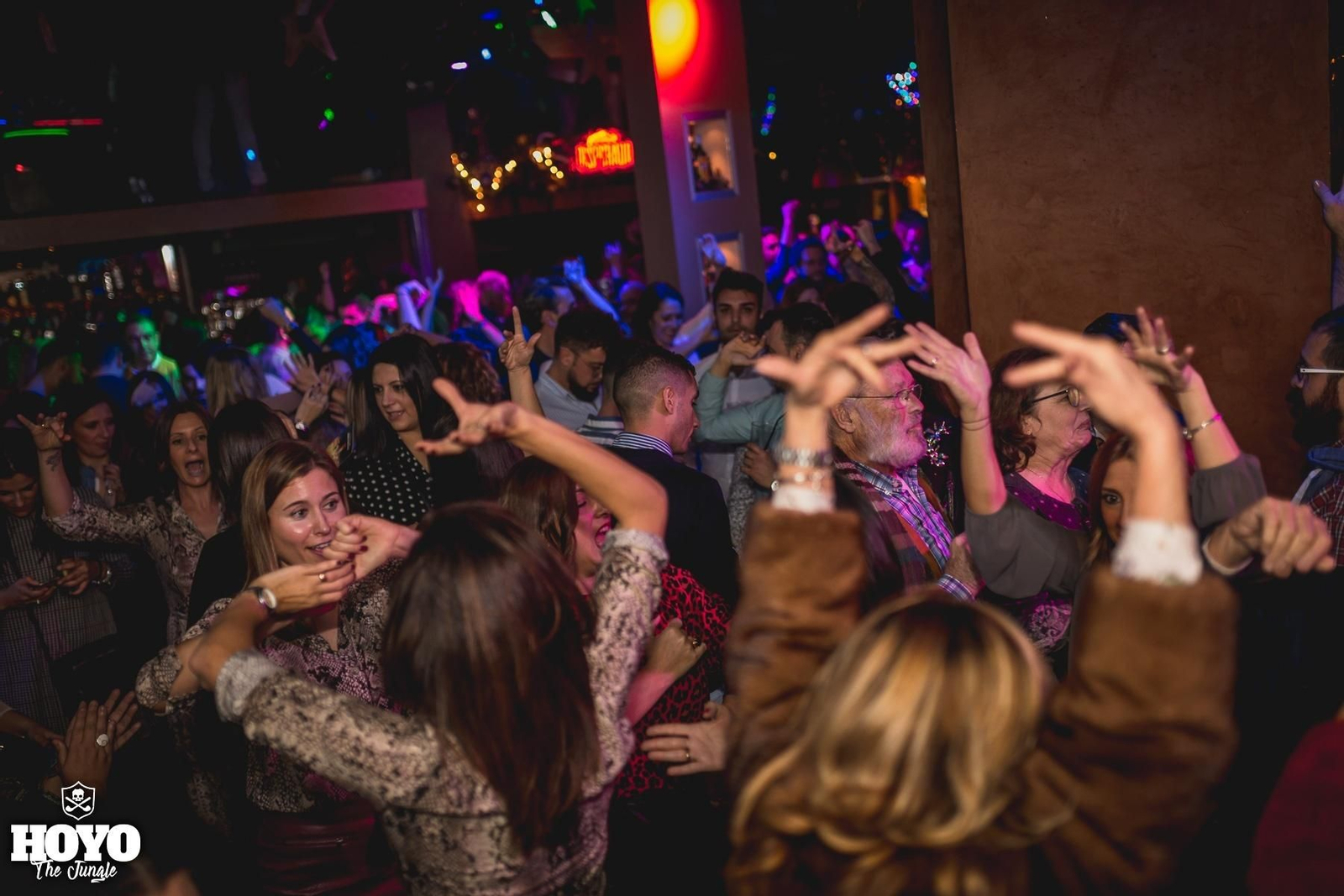 Varias mujeres bailando sevillanas en la pista de baile de una discoteca.