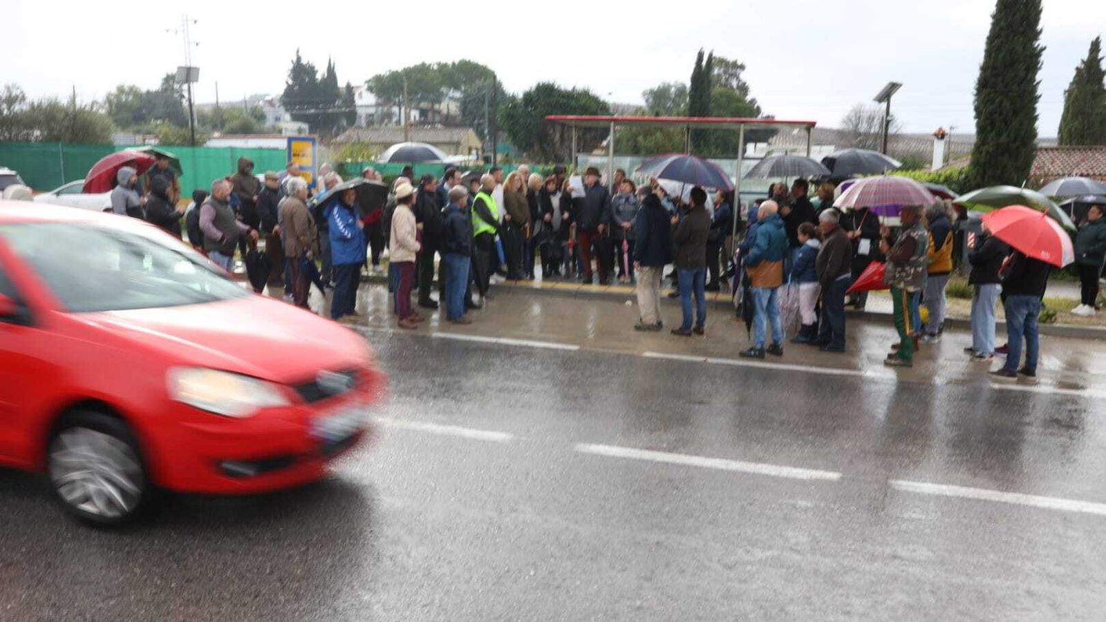 Un coche circula por la A-2003 junto a los participantes en la concentración convocada por la plataforma A-2003.