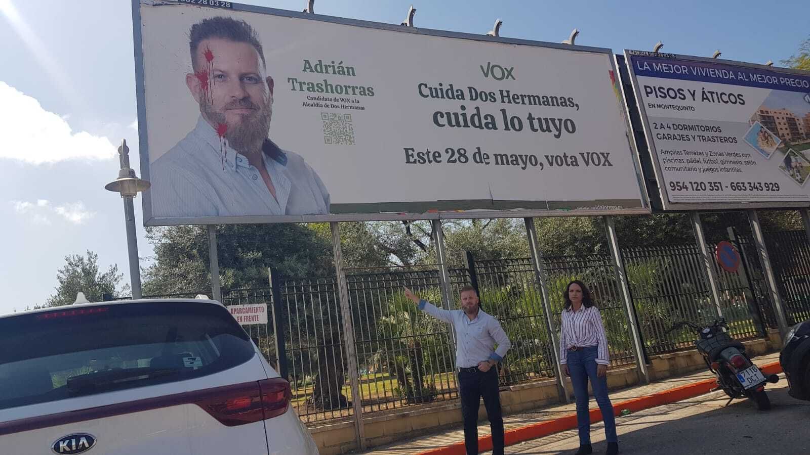 Adrián Trashorras señala la valla con su cara que ha sido vandalizada.