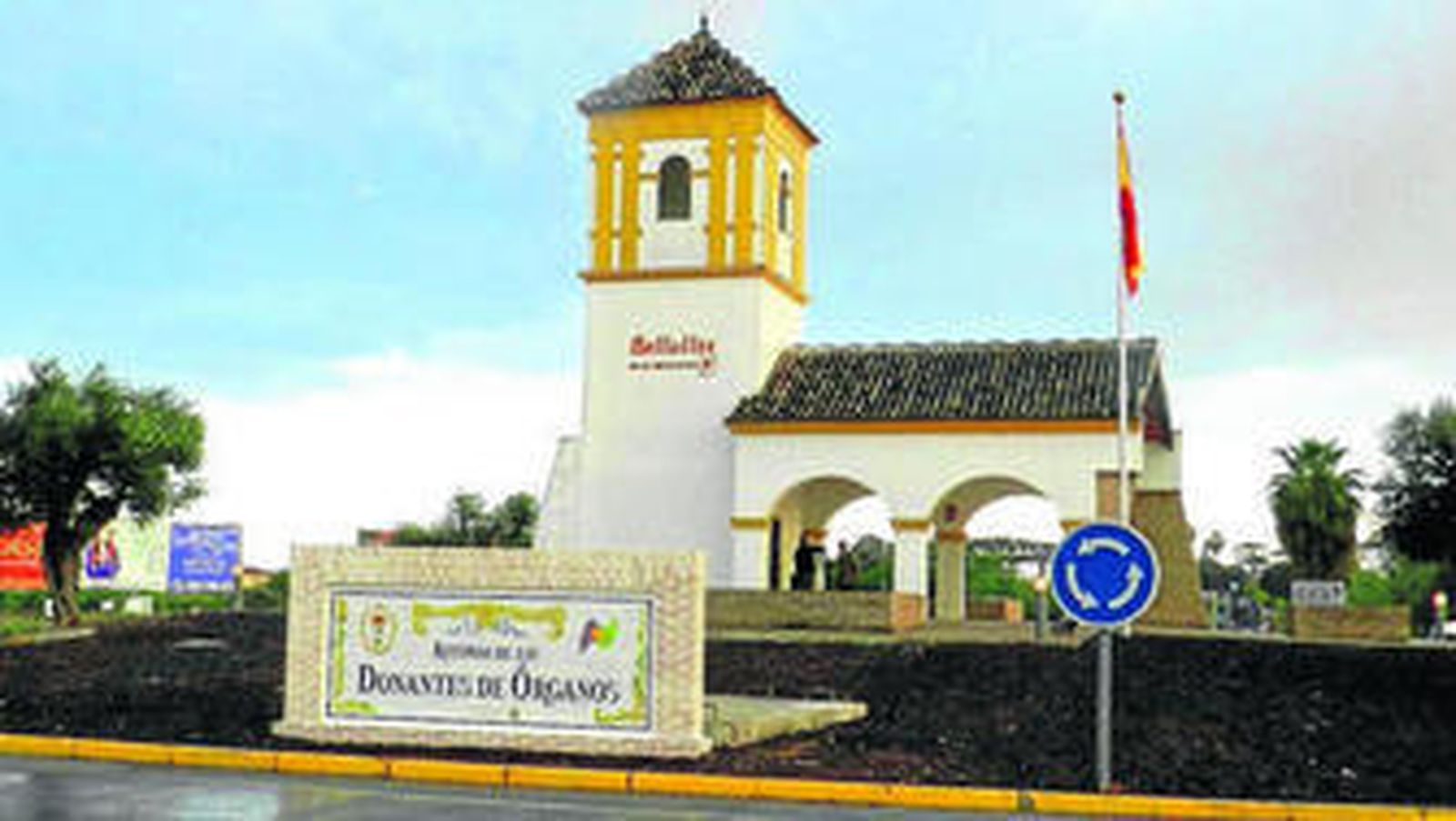 El muro y el azulejo con el que se rotula la rotonda, ubicado al mismo borde de la calzada.