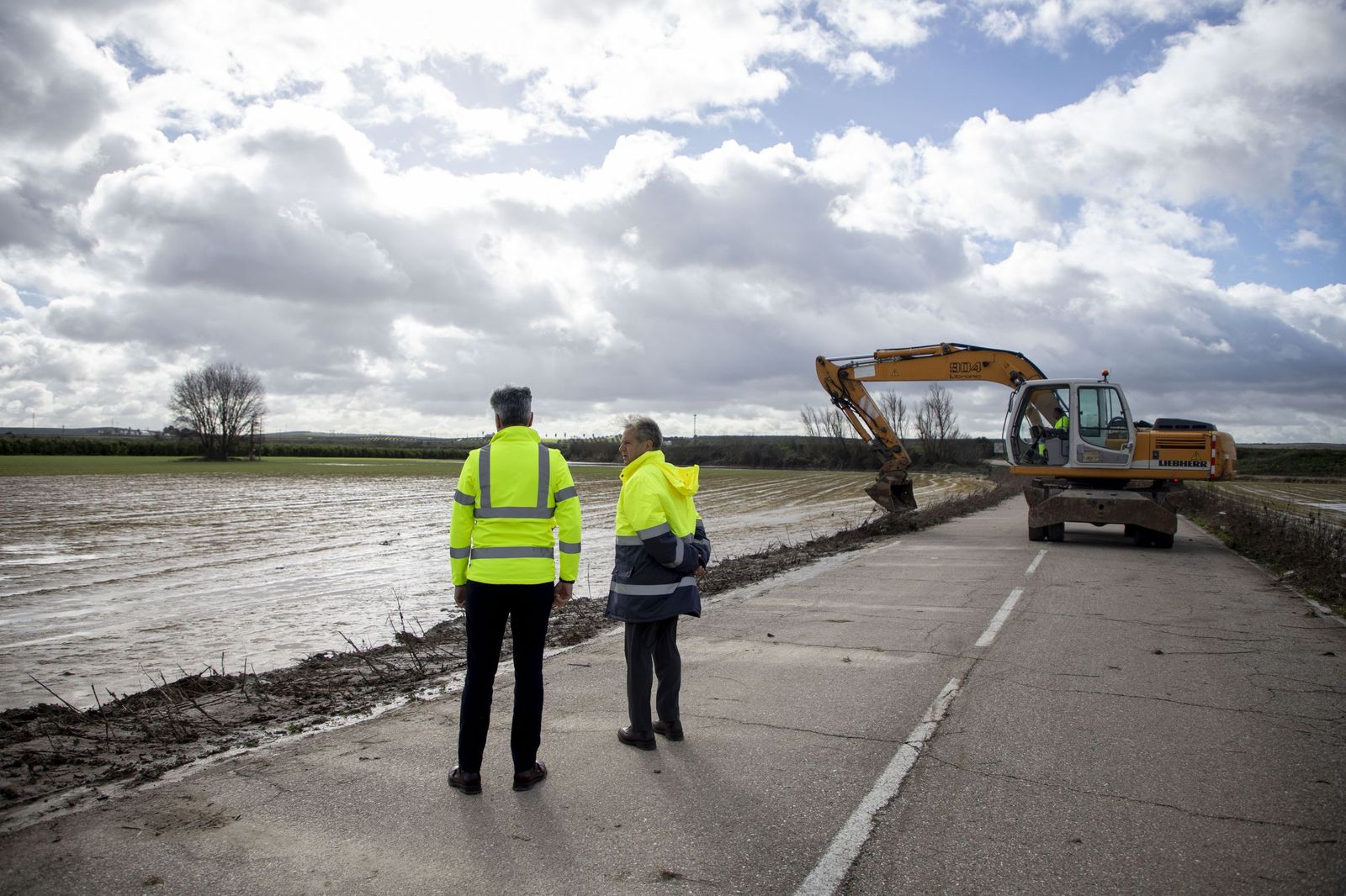 Lorite y Fuentes observan unas tierras anegadas junto a una carretera afectada en Almodóvar del Río.