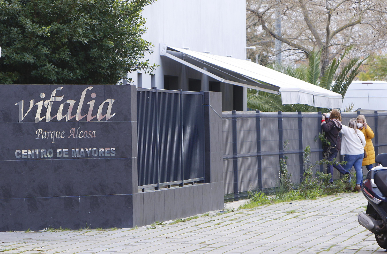Familiares de los usuarios de la residencia Vitalia Parque Alcosa intentan ver a los mayores por las ventanas.