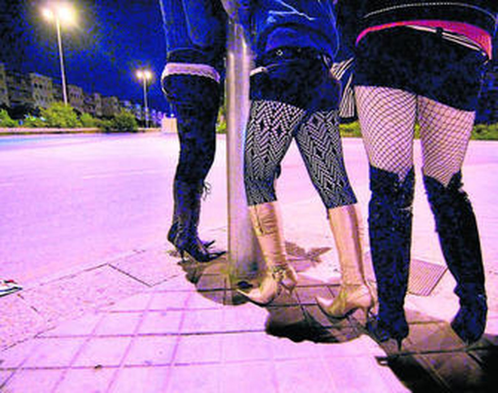 Tres trabajadoras del sexo esperan a clientes en la calle.