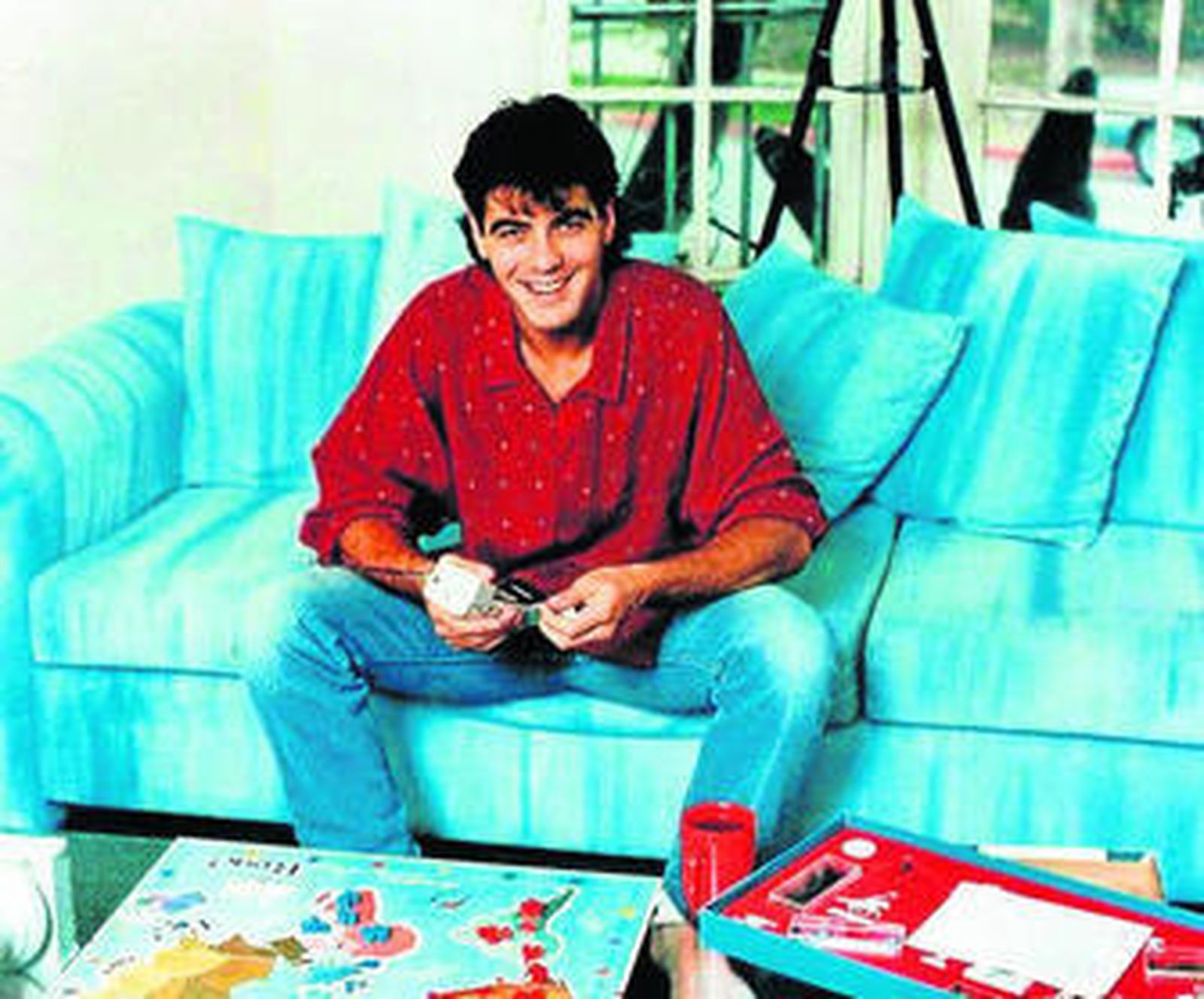 El soltero de Hollywood en los años 80 jugando al Risk con un atuendo informal y desaliñado.