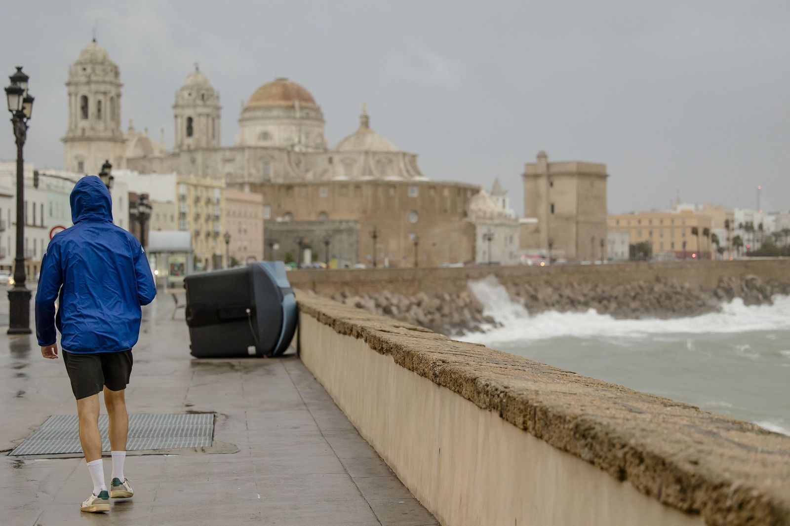 Un hombre camina en un día de lluvia y viento por el Campo del Sur de Cádiz