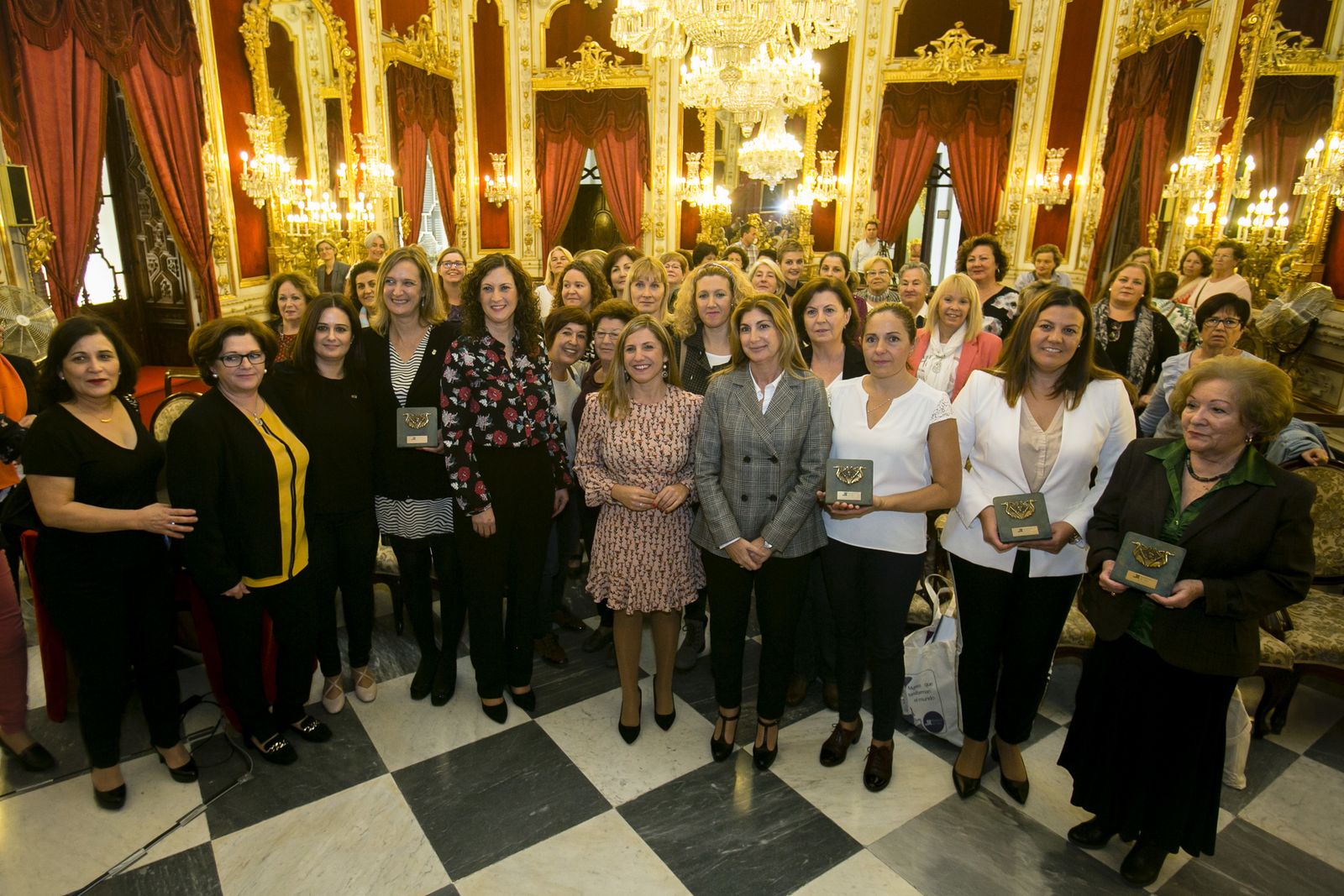 La presidenta y las premiadas posan en el Salón Regio de la Diputación