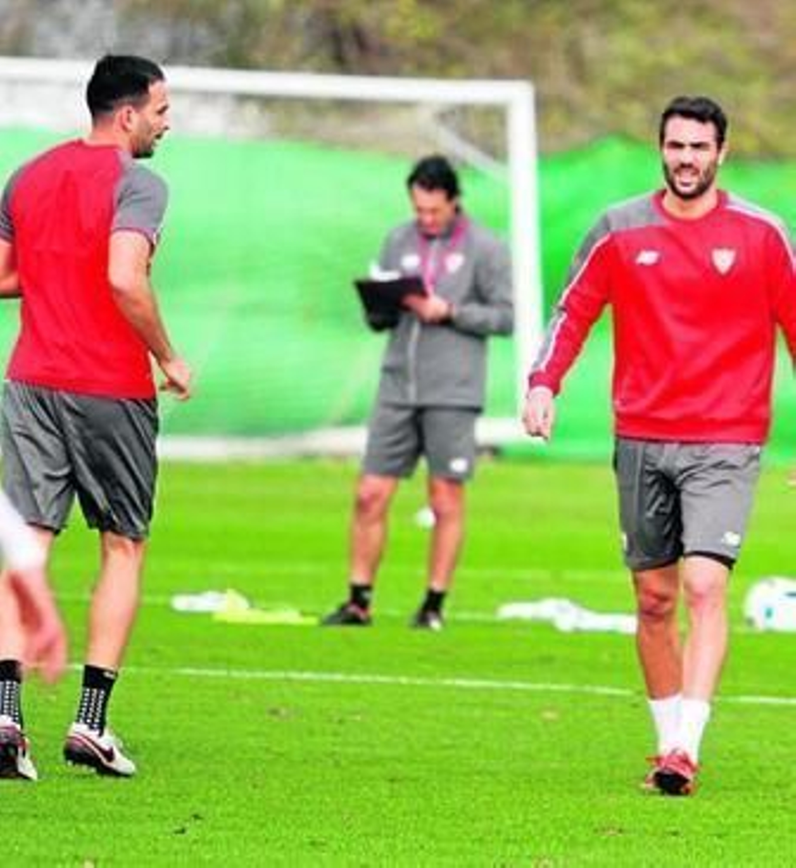 Unai Emery consulta sus anotaciones con Rami e Iborra en primer plano.