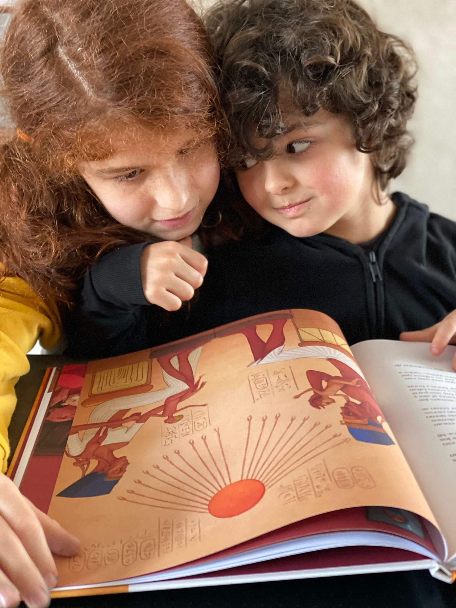 Dos pequeños observan el libro 'Papá'.