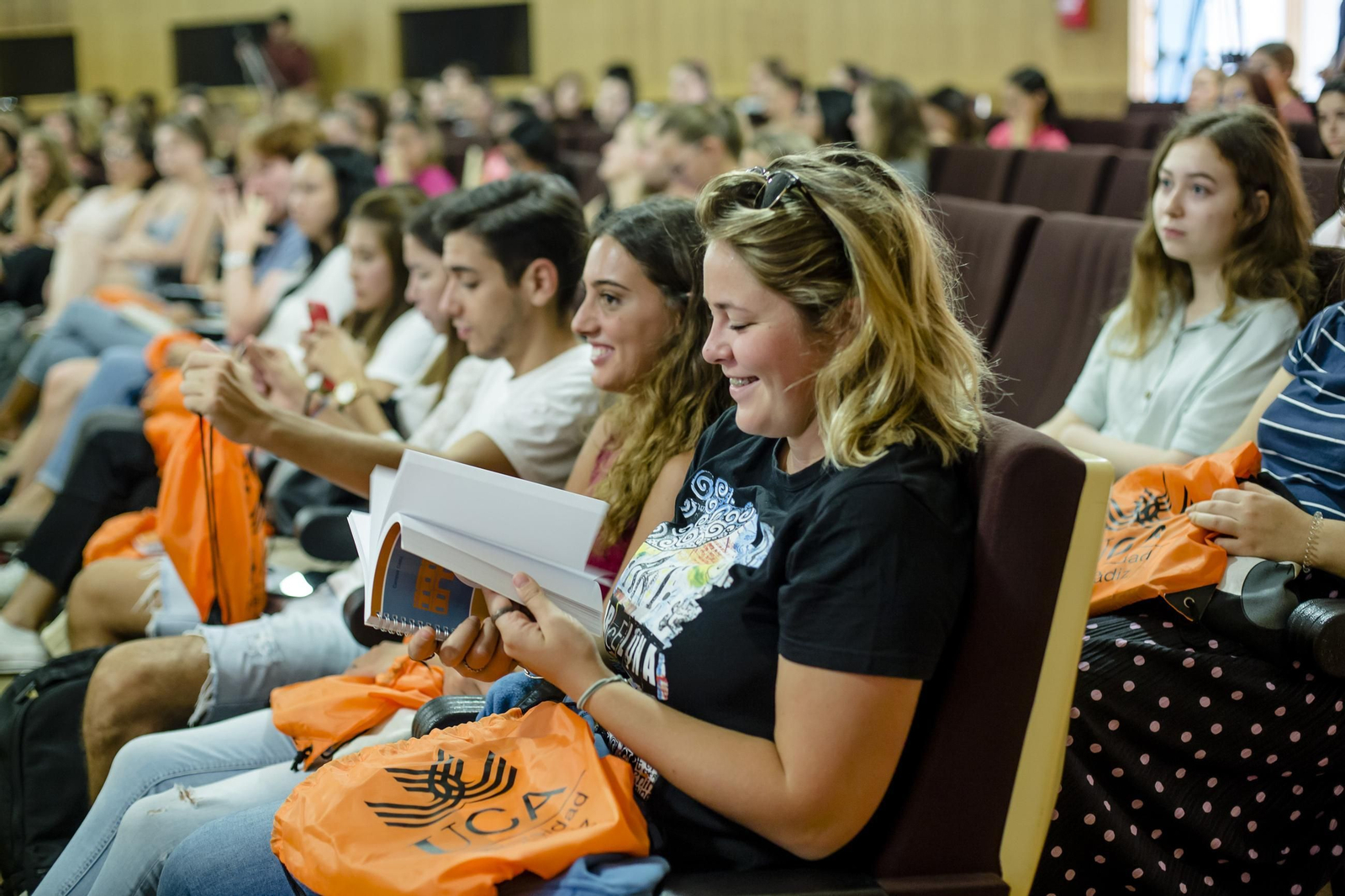 Una erasmus observa sonriente parte del material facilitado por la UCA como bienvenida.
