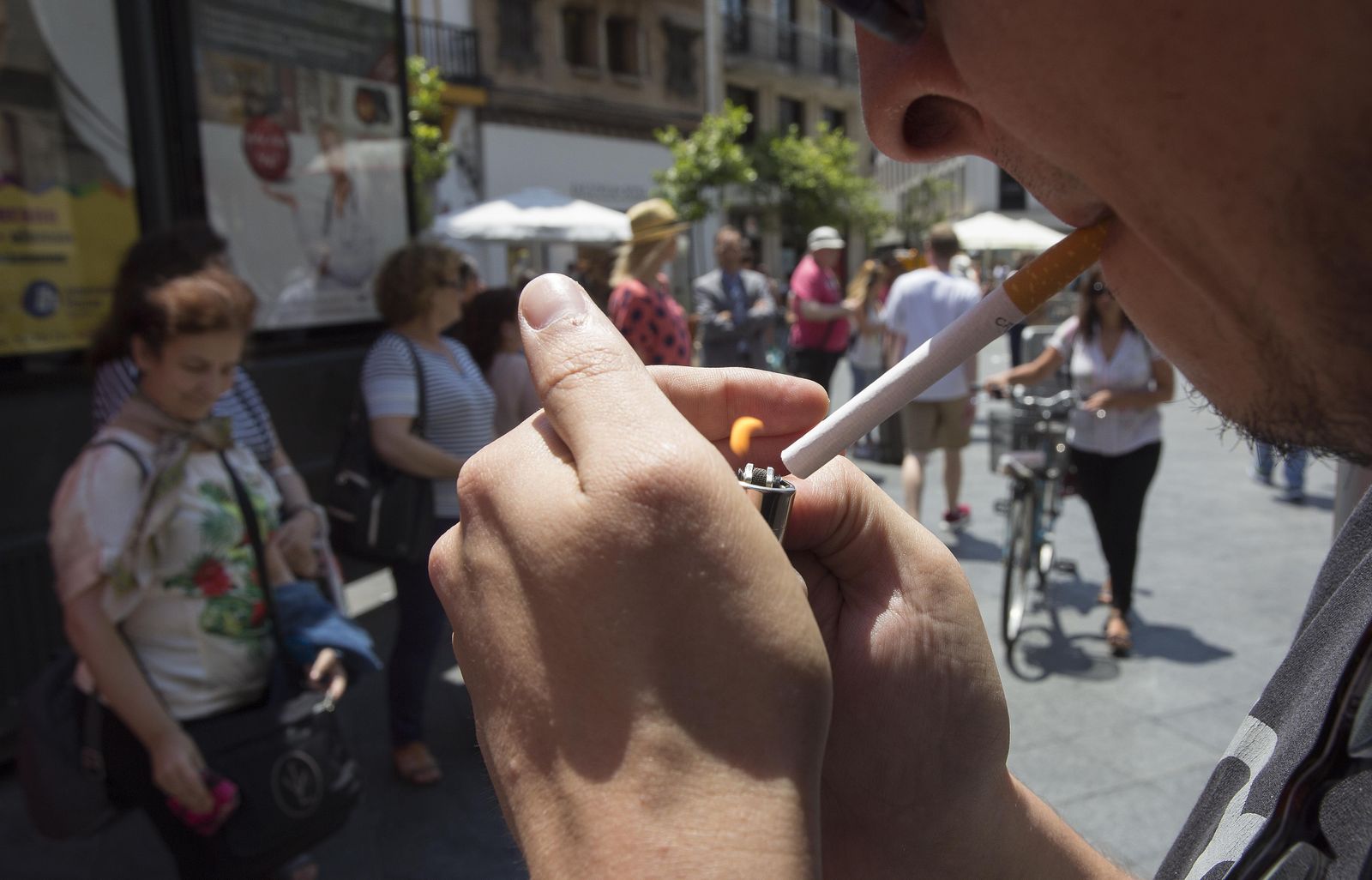 Un joven enciende un cigarrillo en una calle de La Línea.