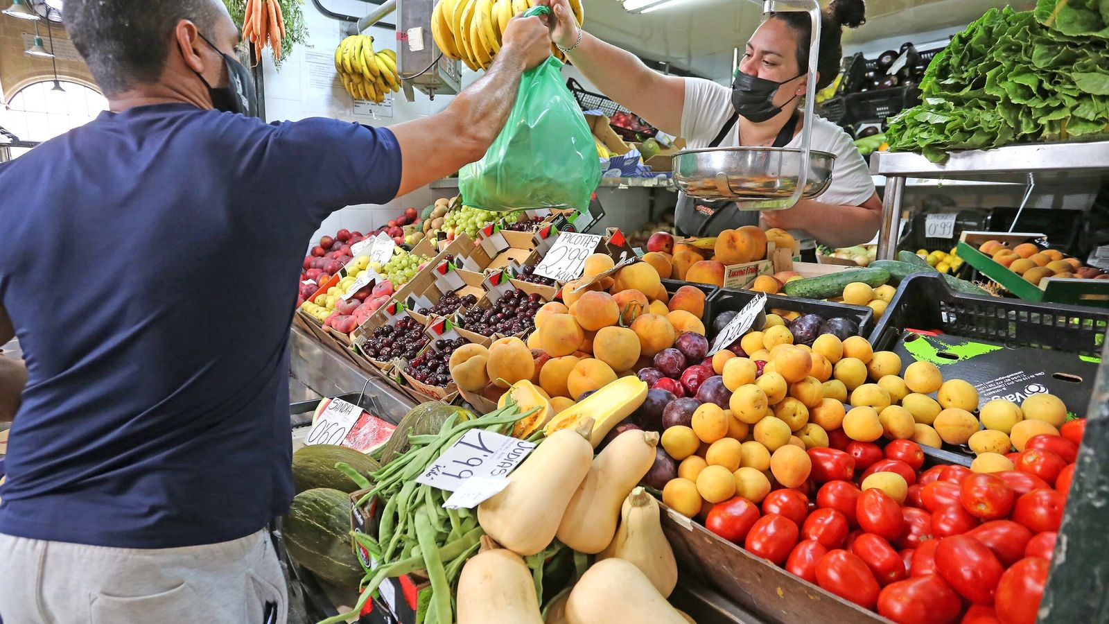 Una tendera entrega la compra a un cliente el pasado sábado en el mercado central de abastos de Jerez.