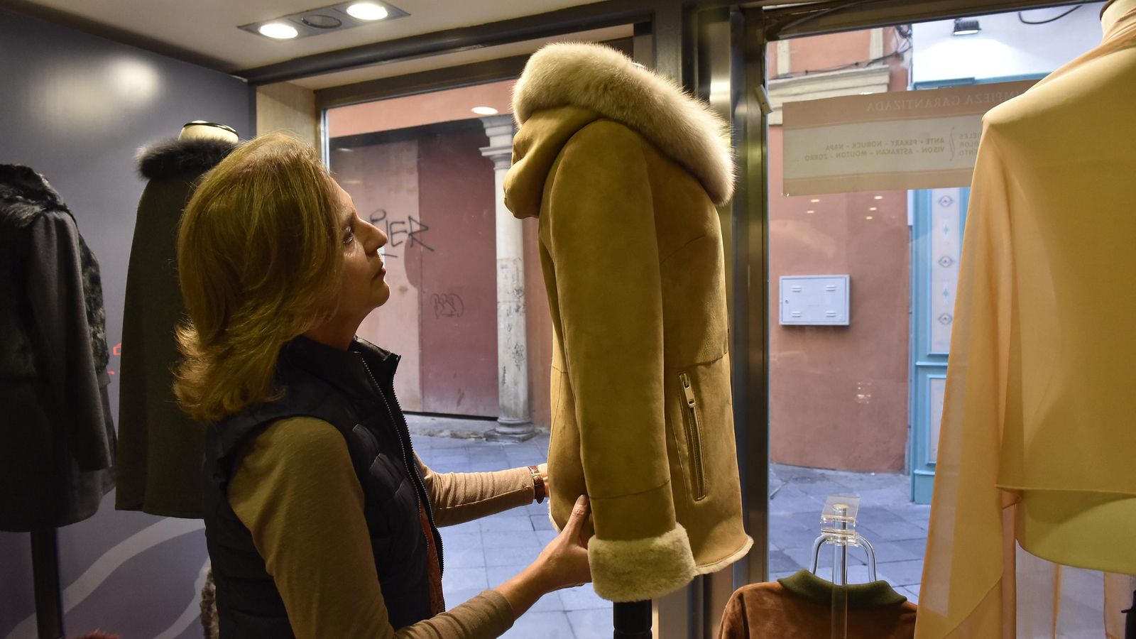 .Emilia Muñoz junto a un 'mouton' en el escaparate de la Peletería Reyes.