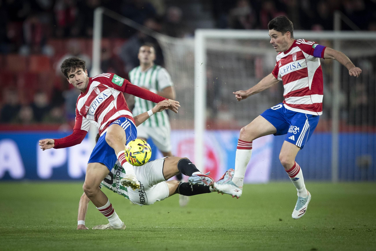 Pedro Alemañ pugna con un rival por el esférico ante la mirada de Sergio Ruiz.