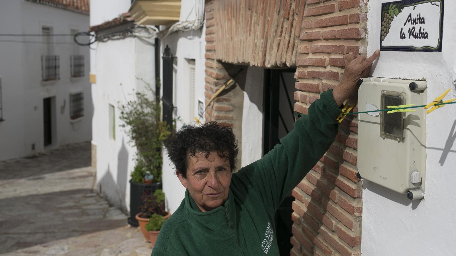 La hija de Anita la Rubia muestra orgullosa la placa de su vivienda.