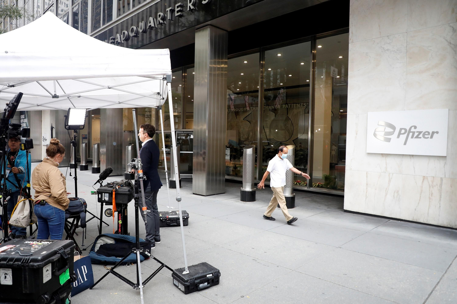 Periodistas de TV retransmiten ante la sede de Pfizer en Nueva York.
