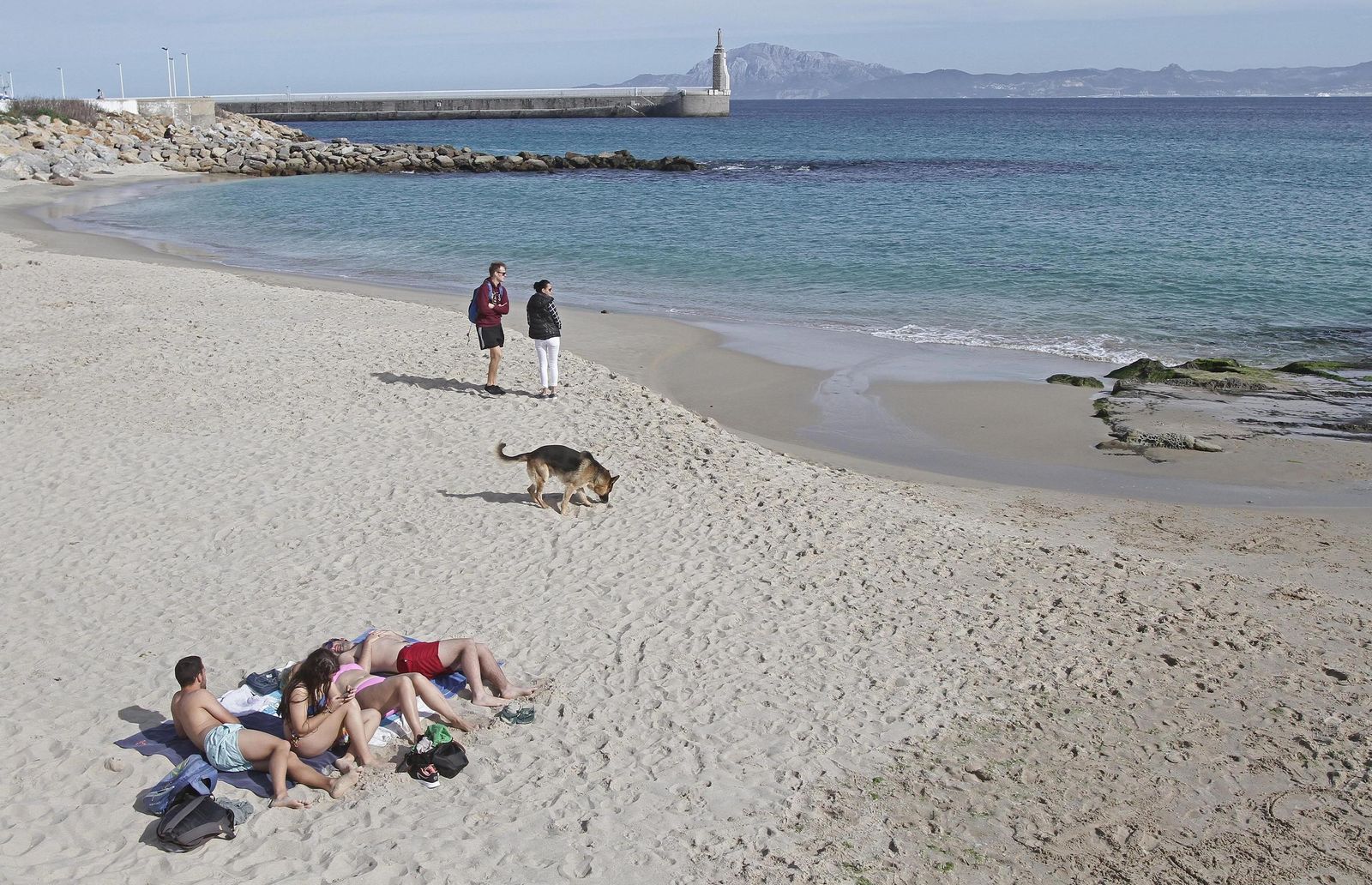 Un grupo de jóvenes toma el sol en Los Lances, en Tarifa.